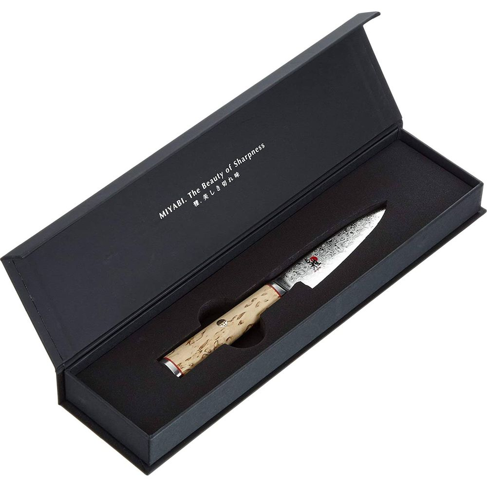 Ein Miyabi-Messer mit hellem Holzgriff und Musterklinge in einer schwarzen Geschenkbox mit weißem Text.
