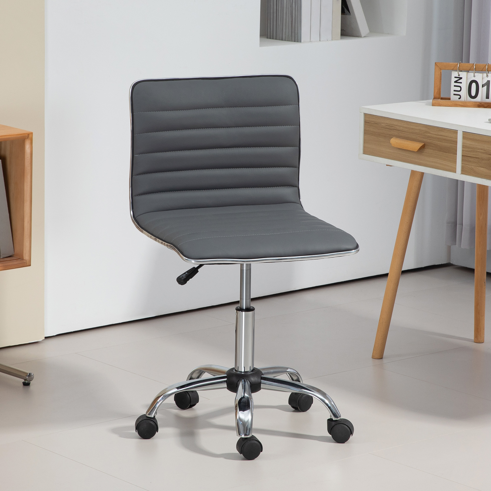 Una sedia da ufficio grigia con gambe in metallo su rotelle in una stanza luminosa.