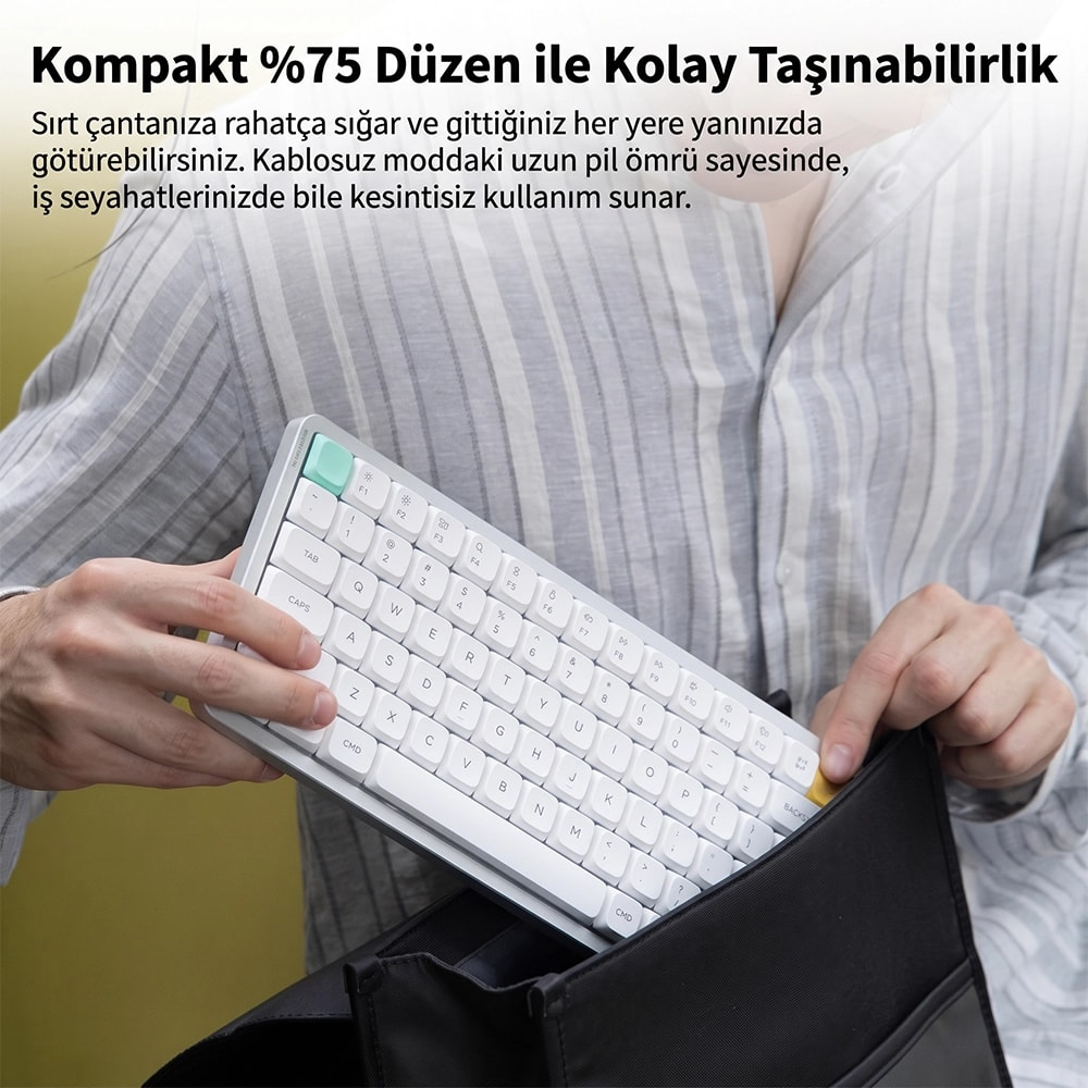 Osoba pakuje białą, kompaktową klawiaturę do czarnej torby.