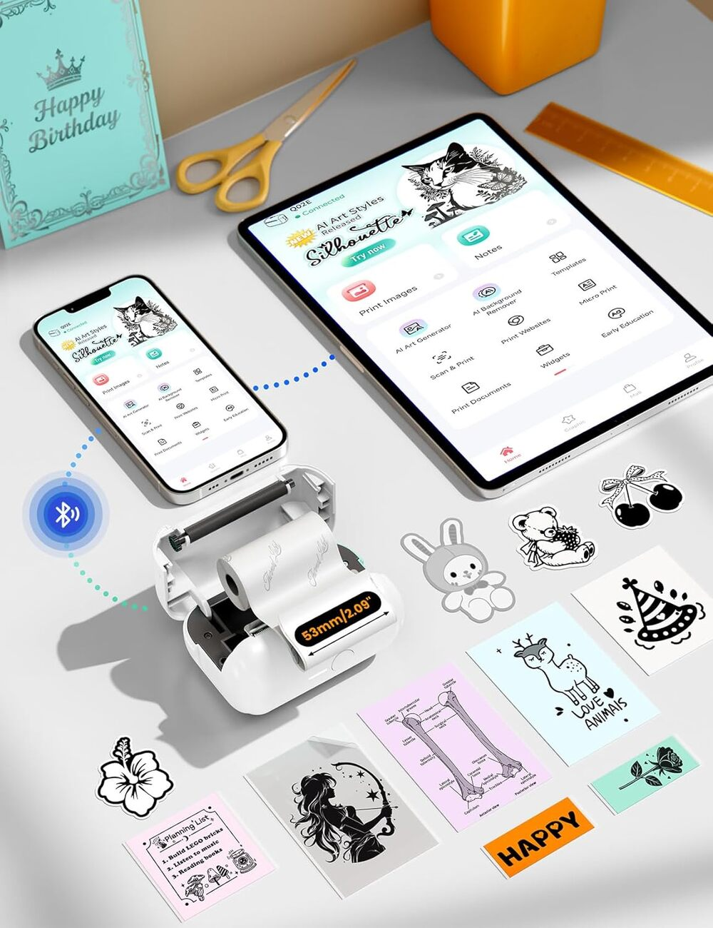 Mini imprimante avec téléphone et tablette, entourée d'autocollants imprimés et de fournitures.