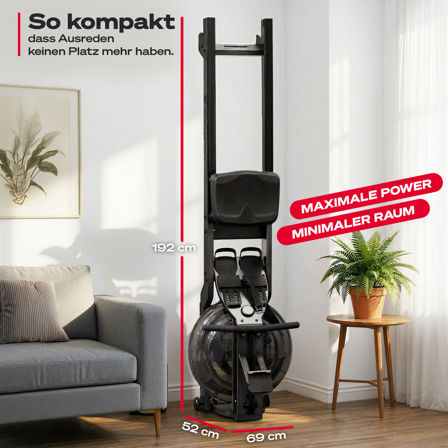 Ein kompaktes schwarzes Rudergerät steht aufrecht in einem Wohnzimmer neben einem grauen Sofa und einer Topfpflanze.