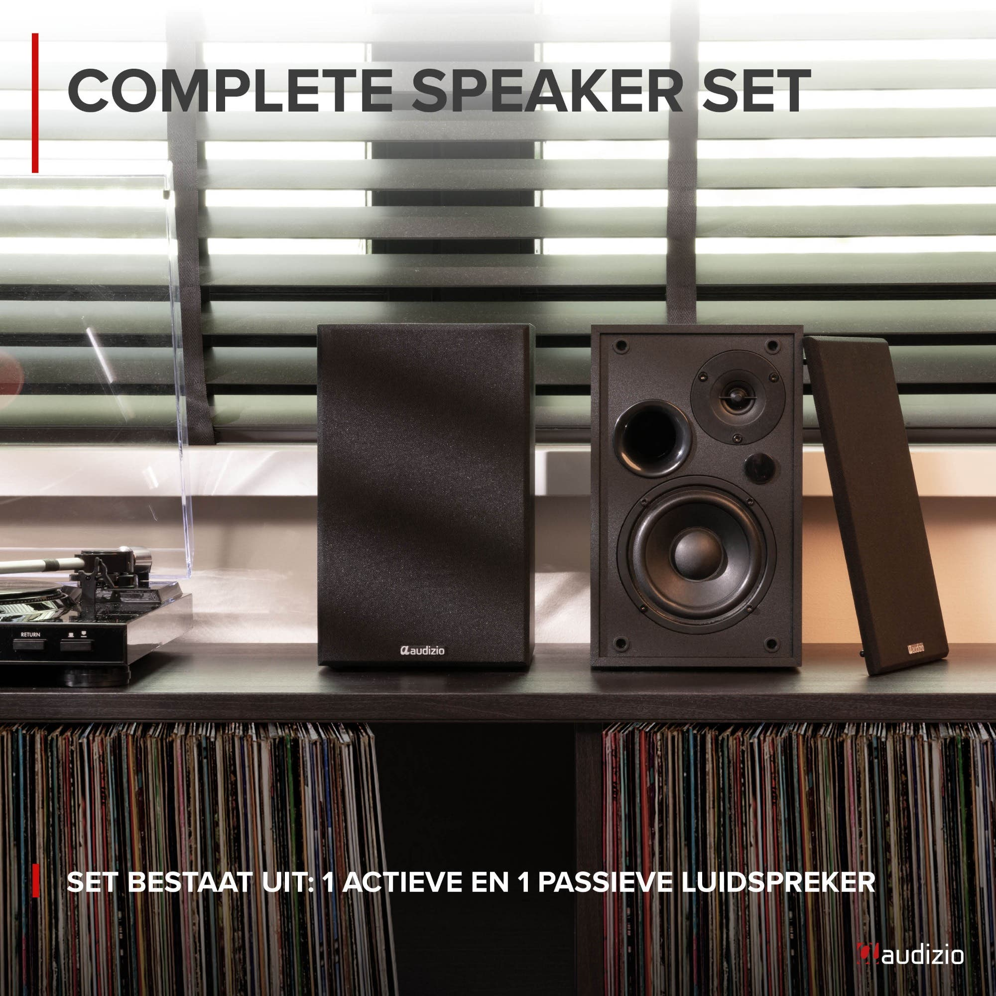 Un juego de altavoces Audizio se encuentra en una estantería con discos de vinilo.