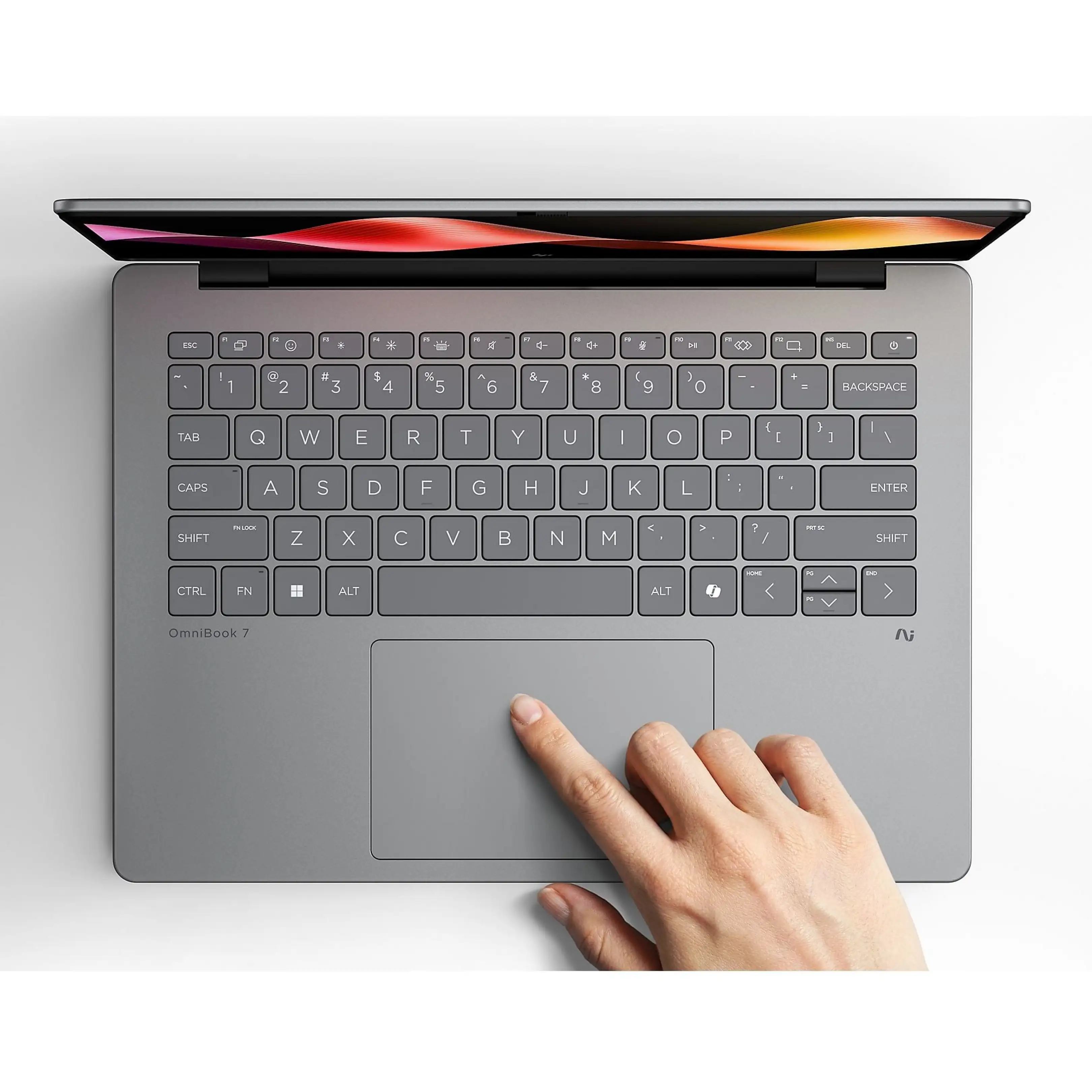 Una mano tocca il touchpad di un laptop grigio OmniBook 7.