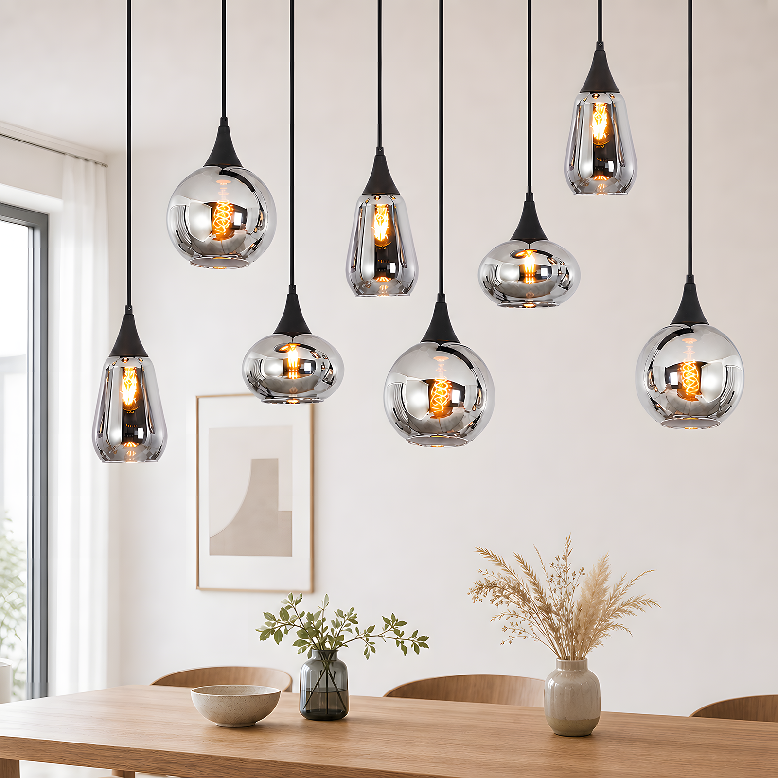 Osiem nowoczesnych lamp wiszących z lustrzanymi kloszami wisi nad drewnianym stołem z wazonami.
