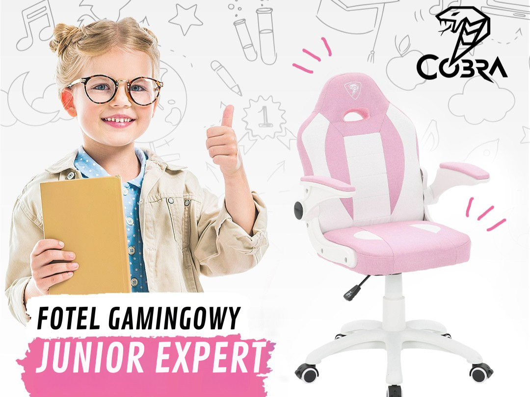 Blond dziewczynka w okularach trzyma książkę i pokazuje kciuk w górę obok różowo-białego fotela gamingowego.