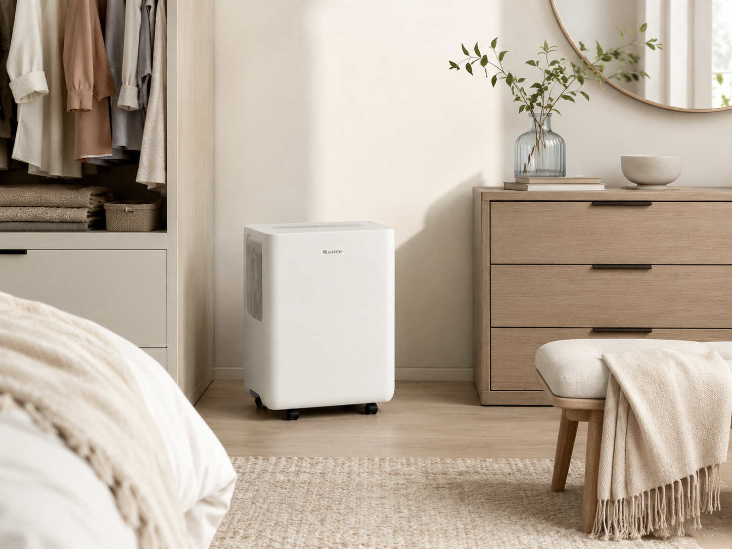 Ein weißer, tragbarer Luftentfeuchter steht in einem hellen, modernen Schlafzimmer zwischen Kleiderschrank und Kommode.