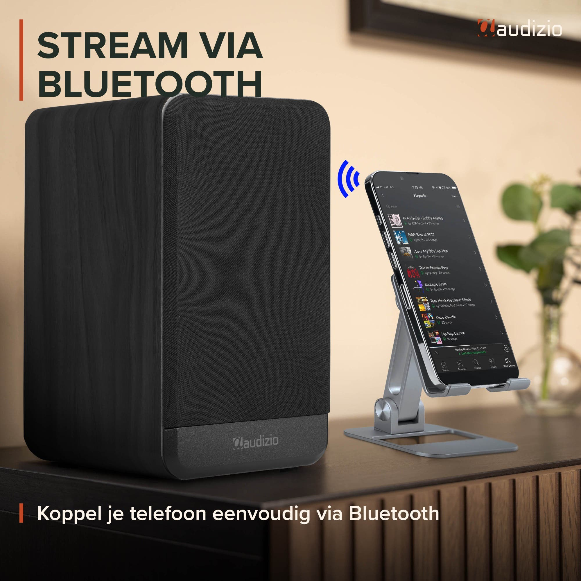 Un altavoz Audizio negro en una mesa junto a un teléfono inteligente.