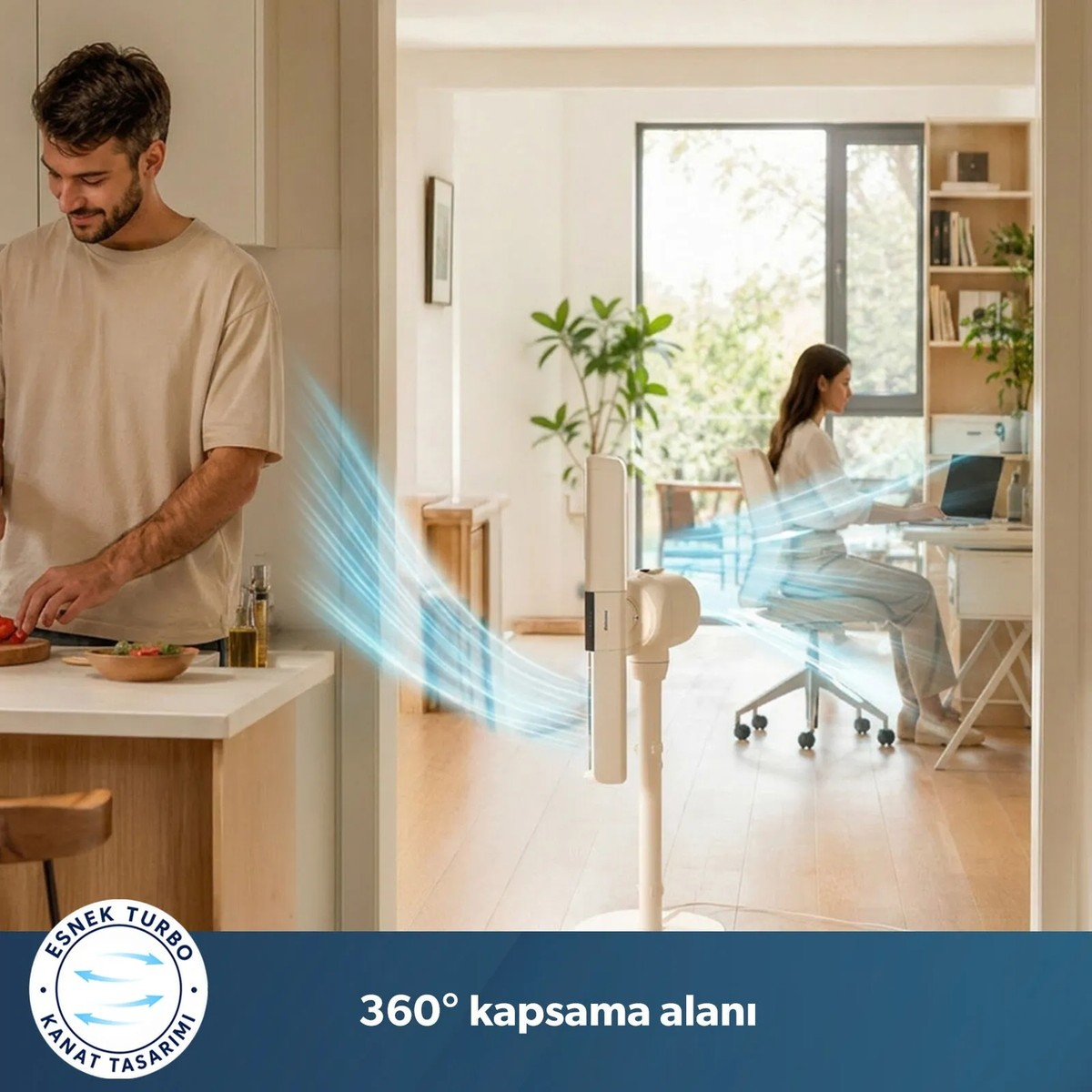 Beyaz bir vantilatör salonda bilgisayarda çalışan kadına doğru hava üflerken mutfakta yemek yapan adam.