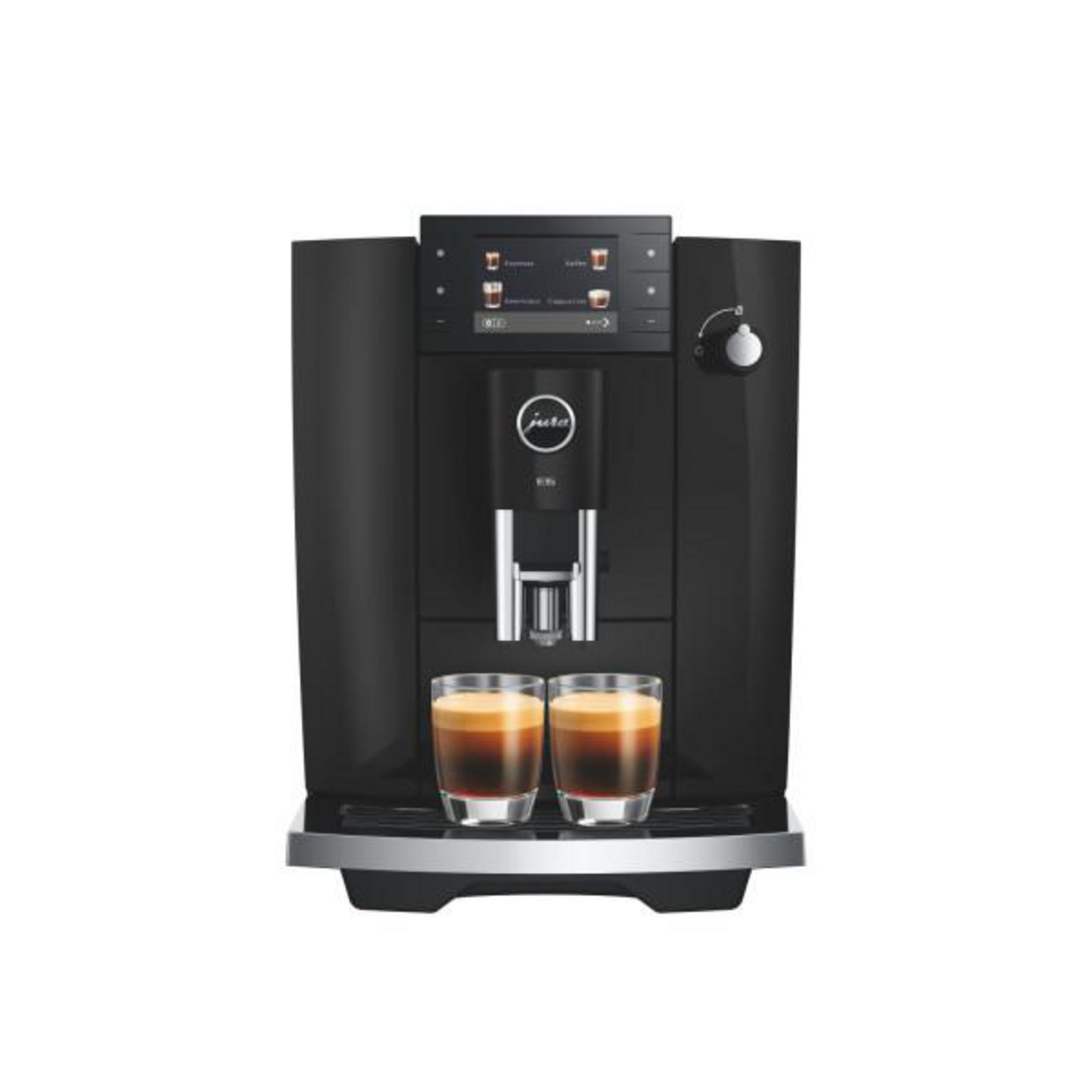 Una macchina da caffè nera Jura con schermo digitale eroga caffè in due tazze di vetro.