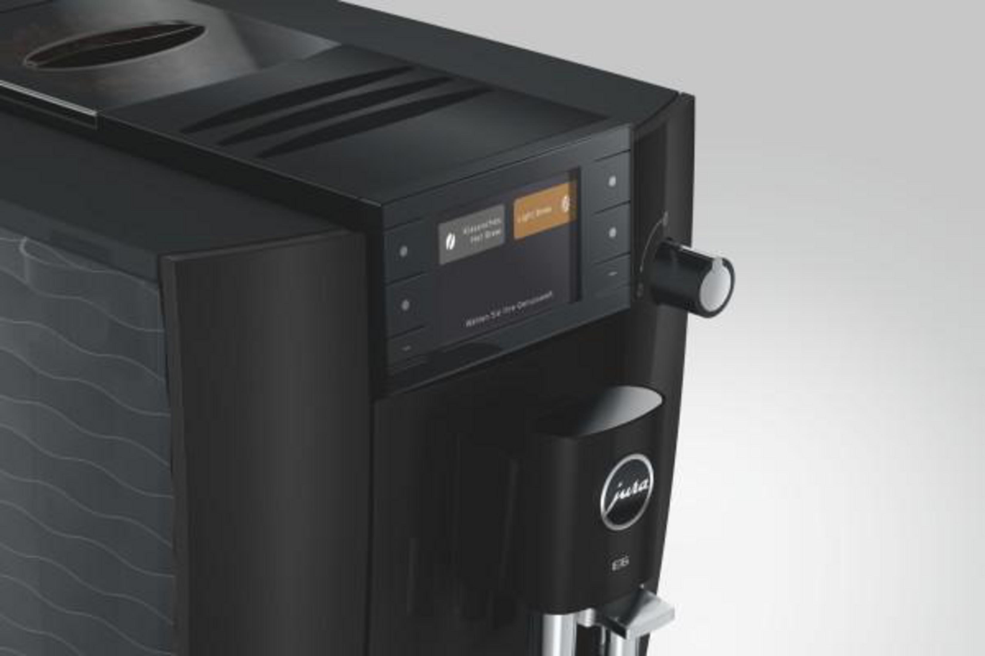 Moderna macchina da caffè nera con display digitale, manopola e erogatore.
