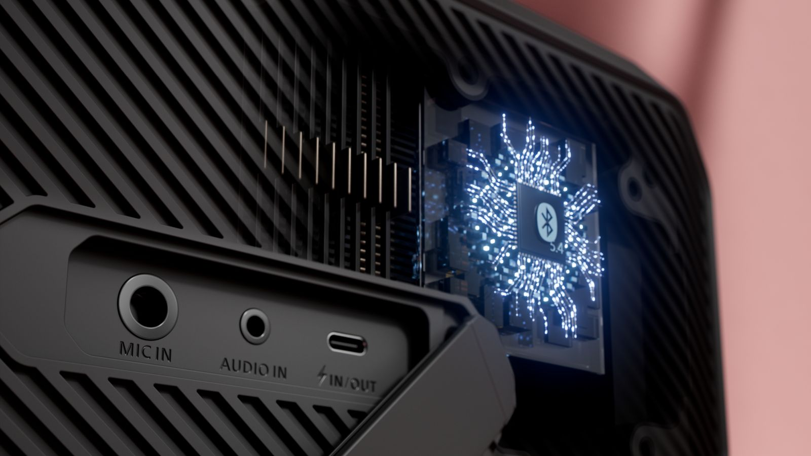 Close-up of a black electronic device featuring audio jacks and a glowing blue Bluetooth circuit board.