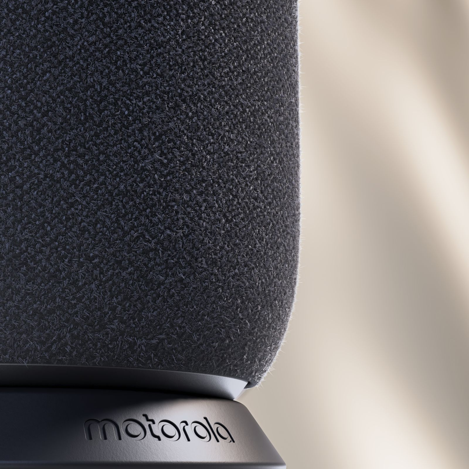 Primo piano di un altoparlante in tessuto grigio con il logo Motorola sulla base su sfondo beige.