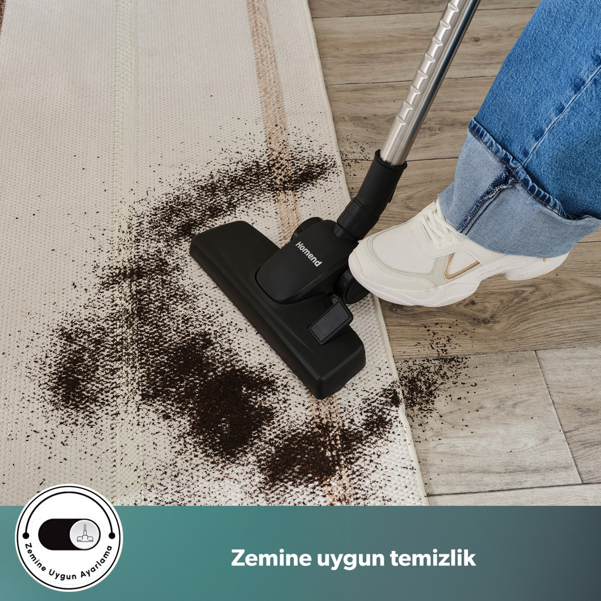 Bir elektrikli süpürge ahşap zemin yanındaki açık renkli halıdaki kahve telvesini temizliyor.
