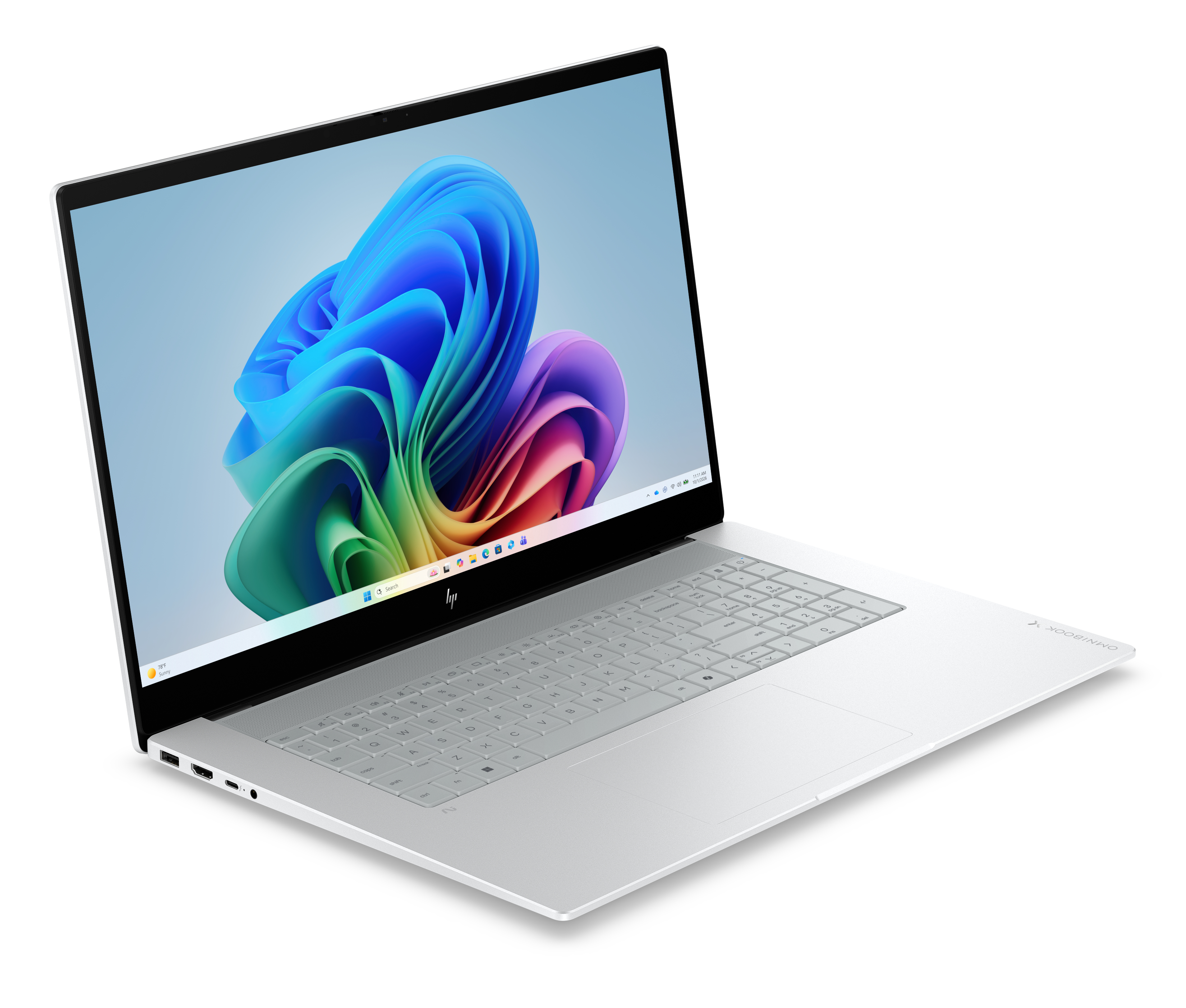 Un laptop argento con schermo aperto mostra uno sfondo astratto colorato, visto da una angolazione leggermente elevata.