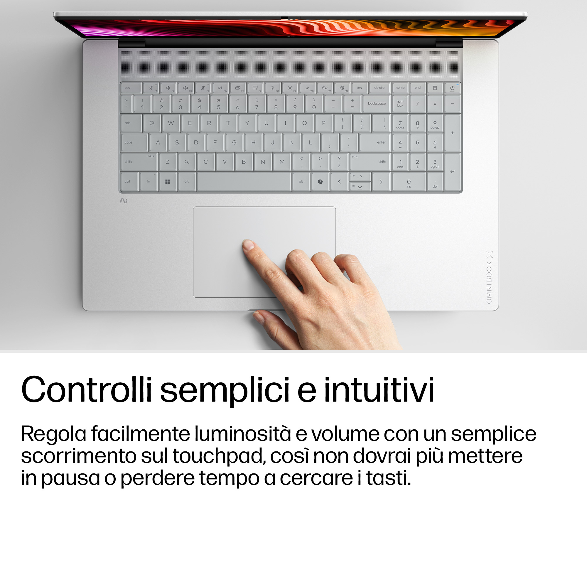 Una mano usa il touchpad di un laptop argento, visto dall'alto con testo in italiano.