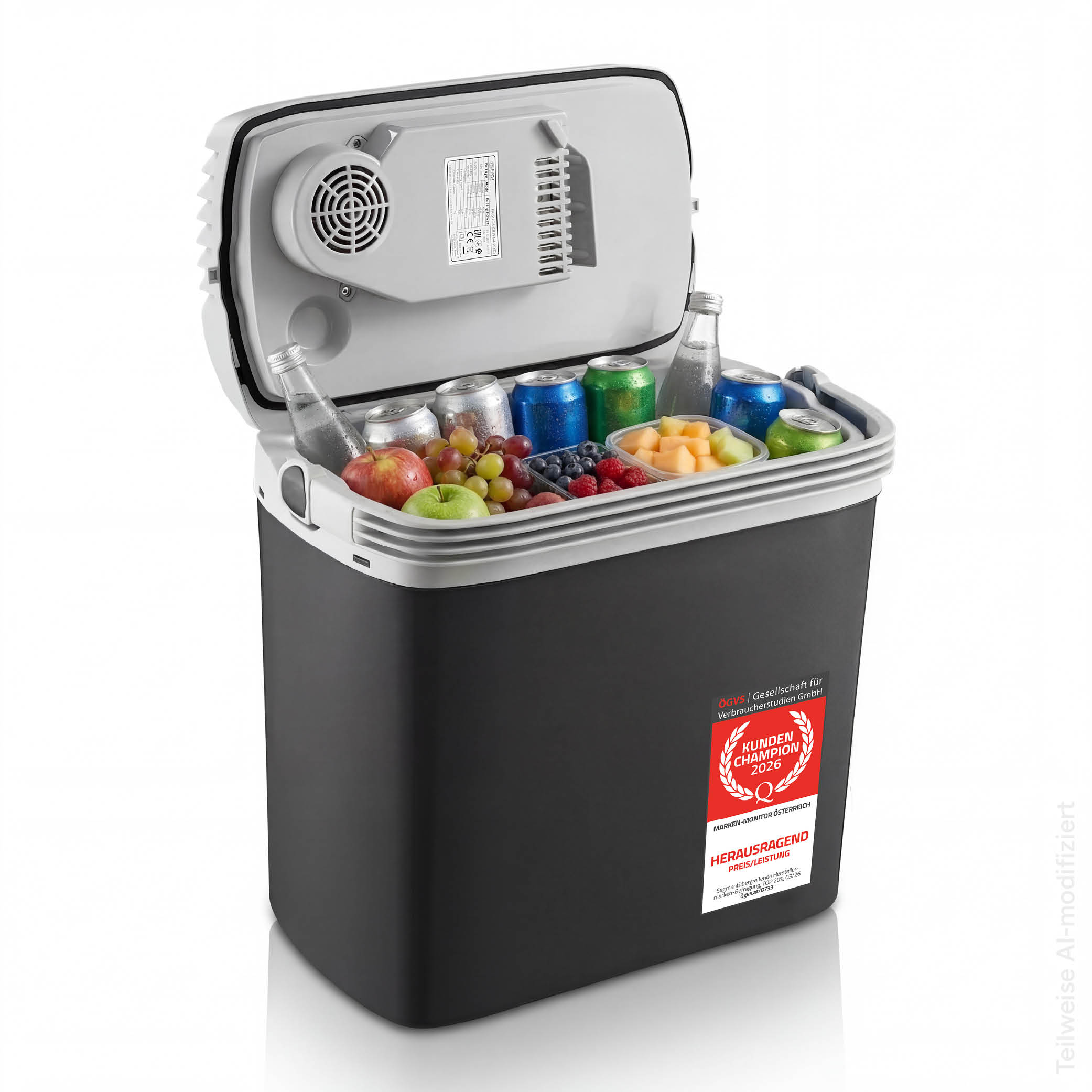 Eine offene schwarz-graue Kühlbox, gefüllt mit Getränken und frischem Obst vor weißem Hintergrund.