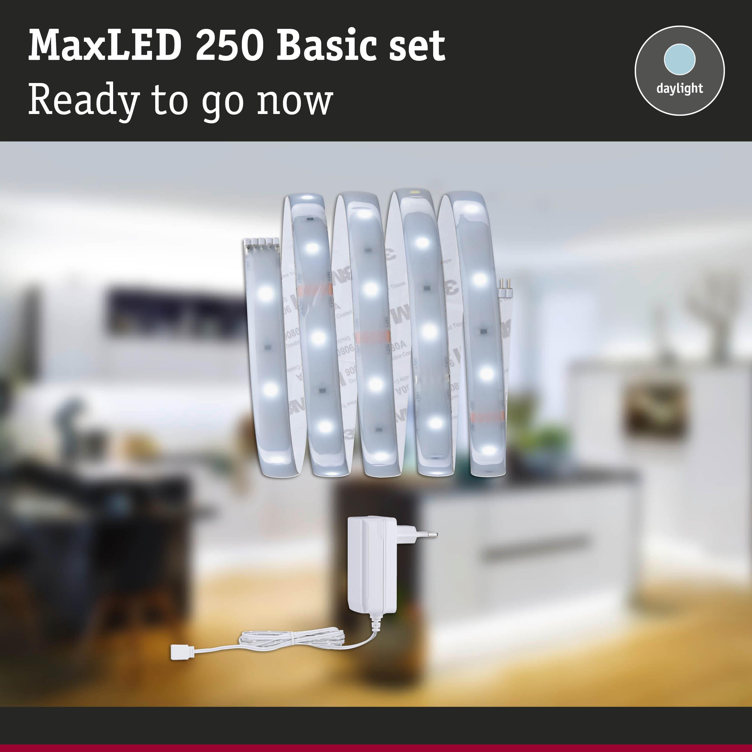 MaxLED 250 Basic Set, Lichtstreifen und weißes Netzteil vor verschwommenem Raum.