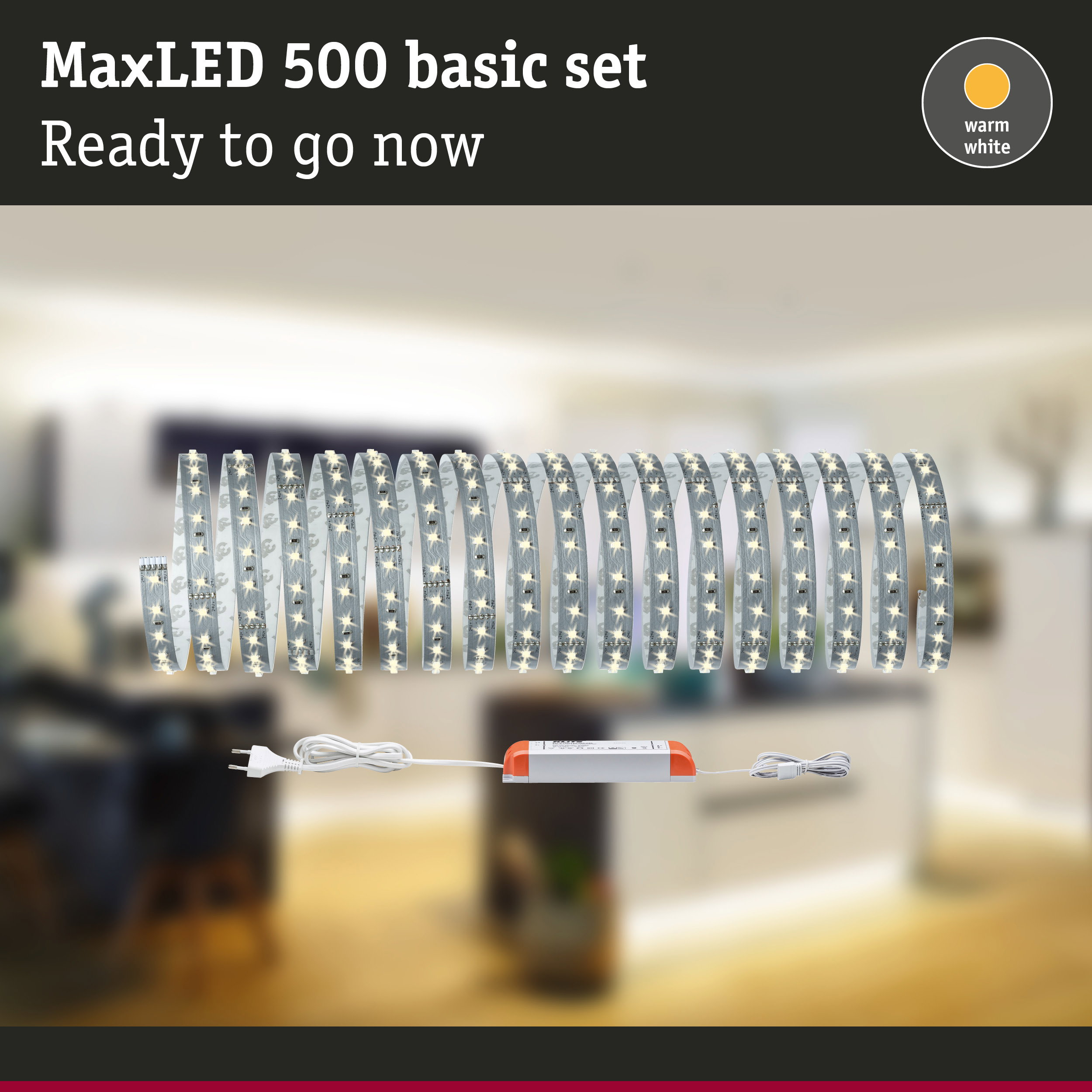 Zestaw podstawowy taśmy LED MaxLED 500 z zasilaczem na rozmytym tle pokoju.