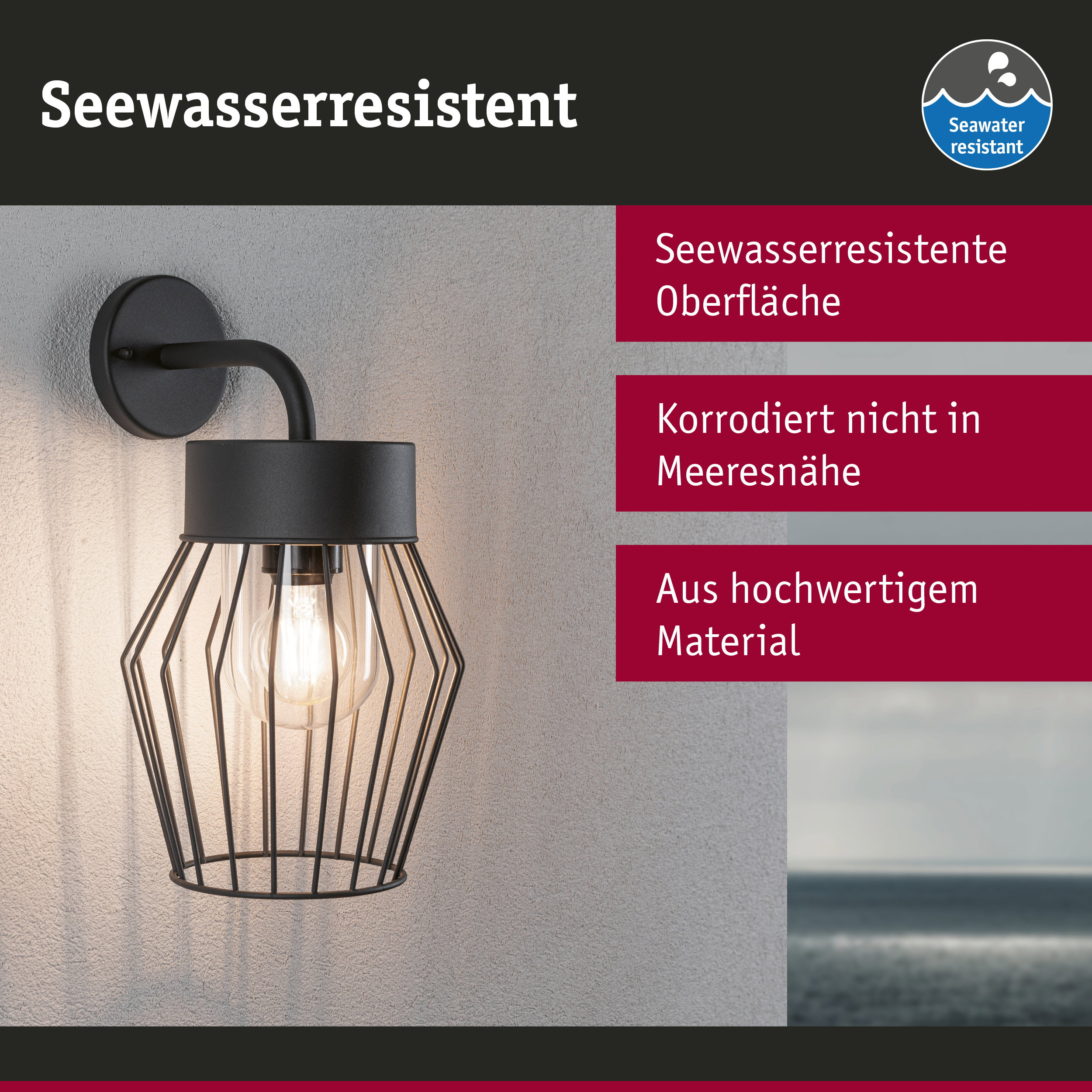 Schwarze, seewasserresistente Wandlampe mit Metallkäfig und Glühbirne an einer grauen Wand.