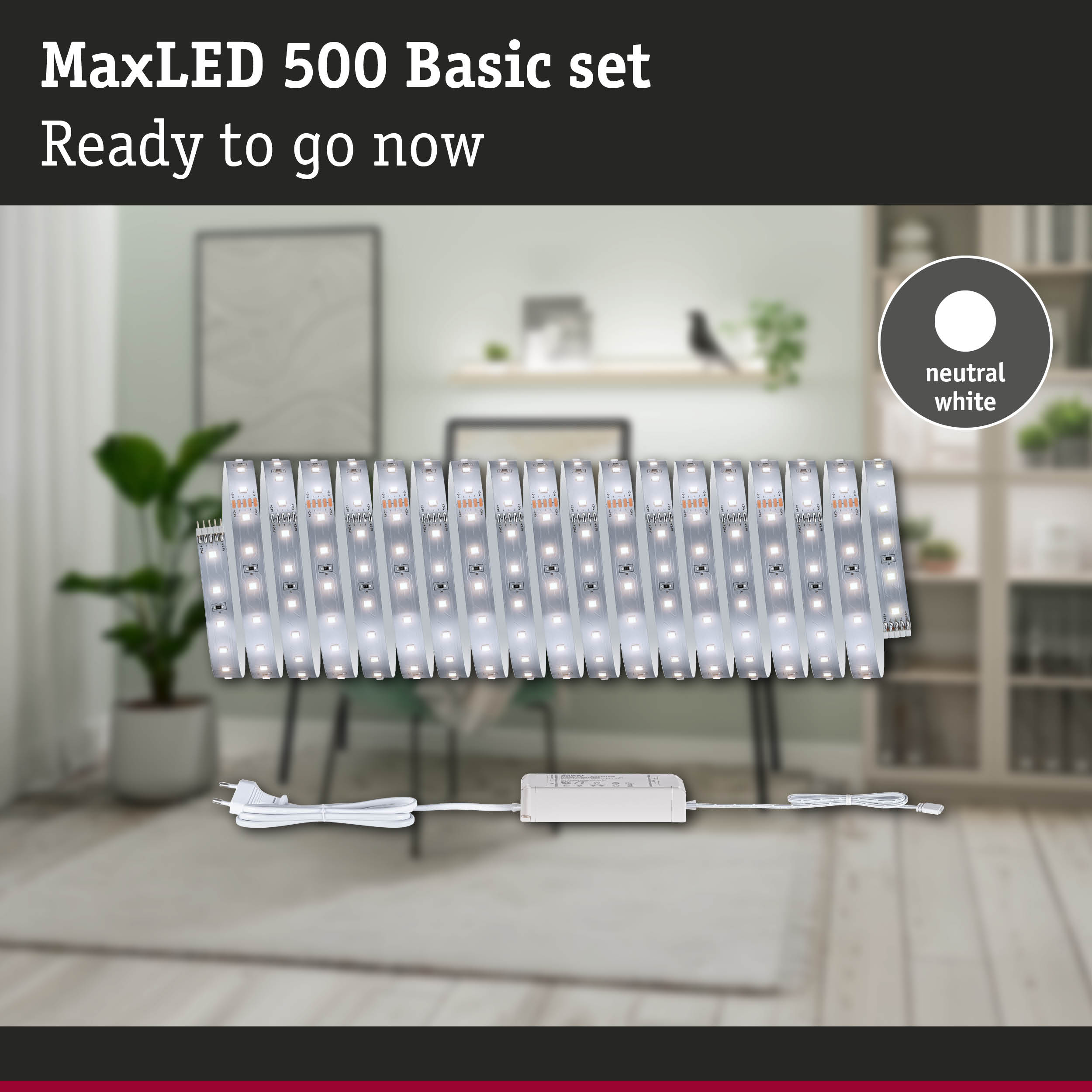 MaxLED 500 Basis-Set mit neutralweißen LED-Streifen, Netzteil und Stecker vor einem unscharfen Raum.