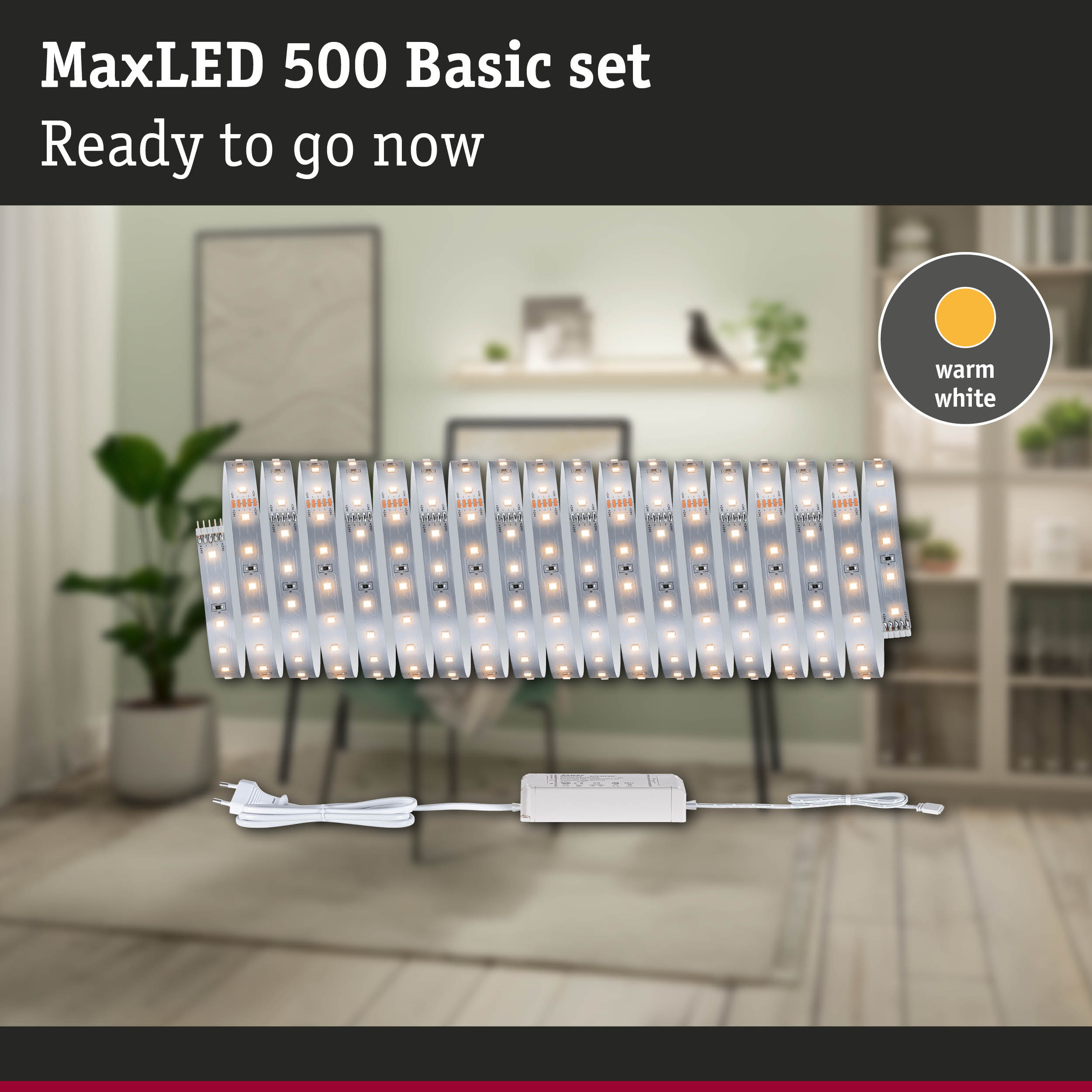 MaxLED 500 Basic Set mit warmweißen LEDs vor einem verschwommenen Wohnzimmer.