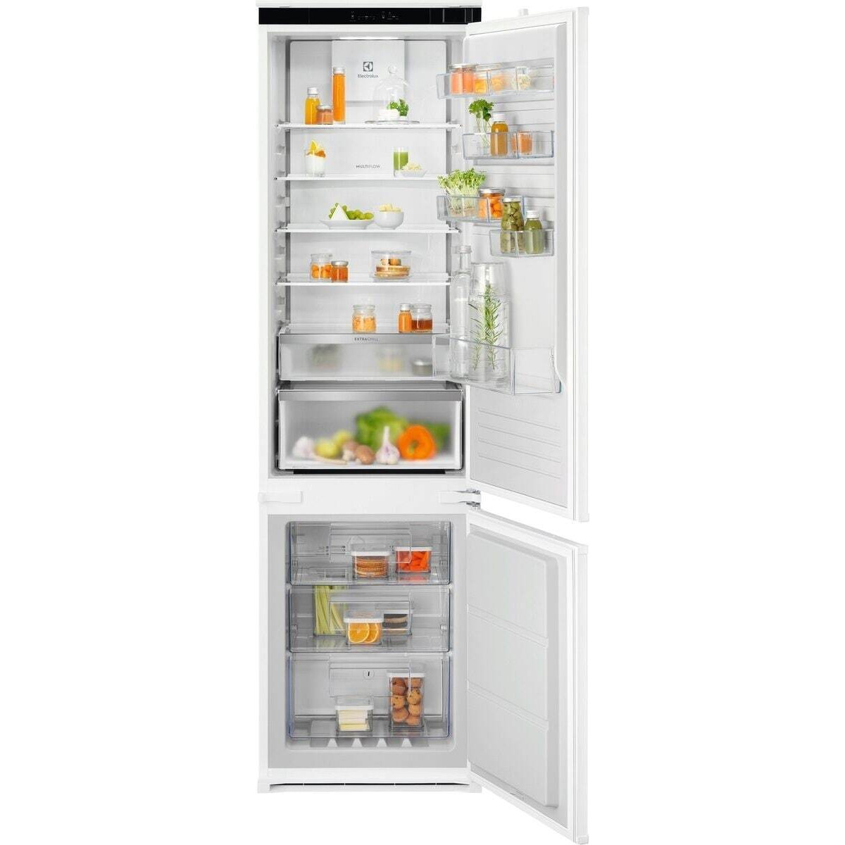 Un frigorifero bianco aperto con ripiani pieni di barattoli, verdure fresche e frutta all'interno.