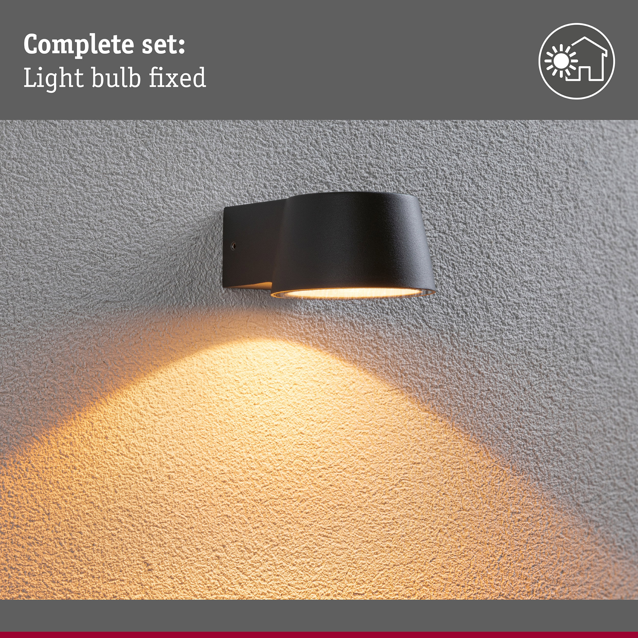Czarna lampa ścienna na szarej ścianie zewnętrznej rzuca ciepłe światło w dół.