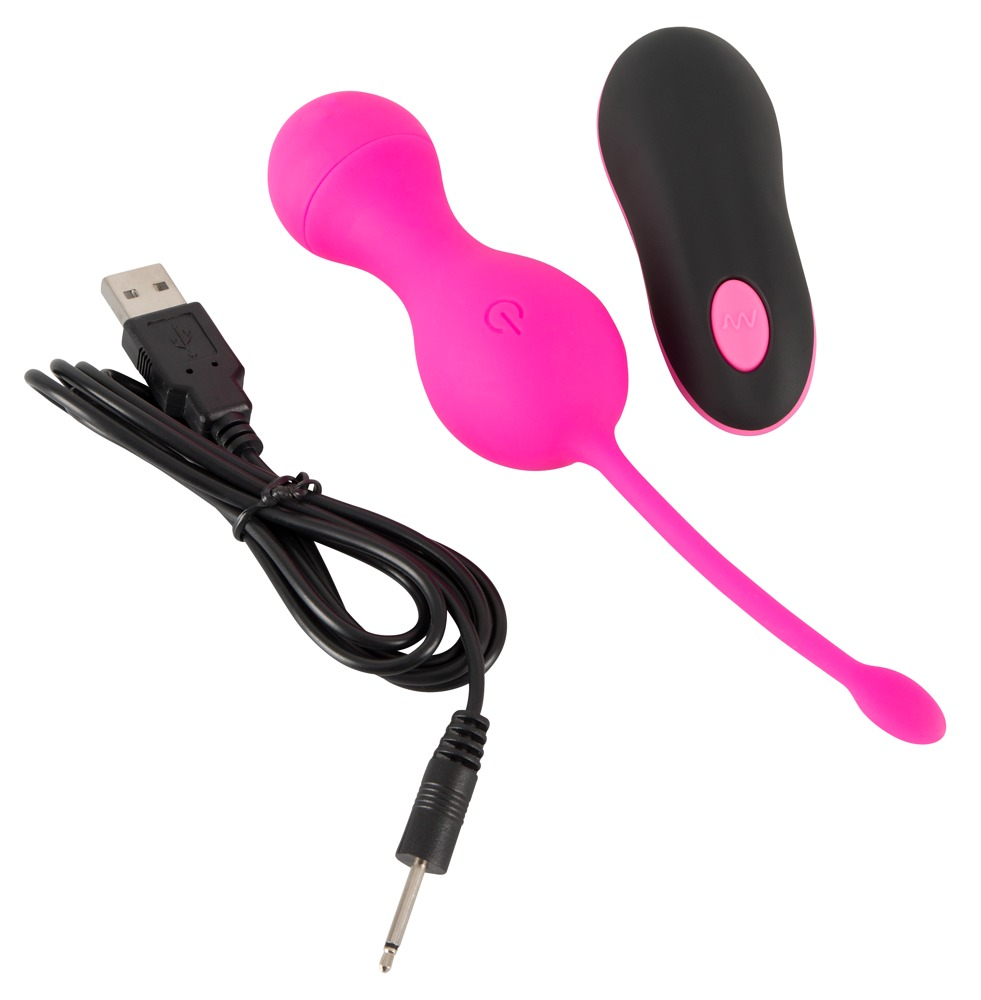 Ein pinkes Vibrationsspielzeug mit USB-Ladekabel und schwarzer Fernbedienung vor weißem Hintergrund.