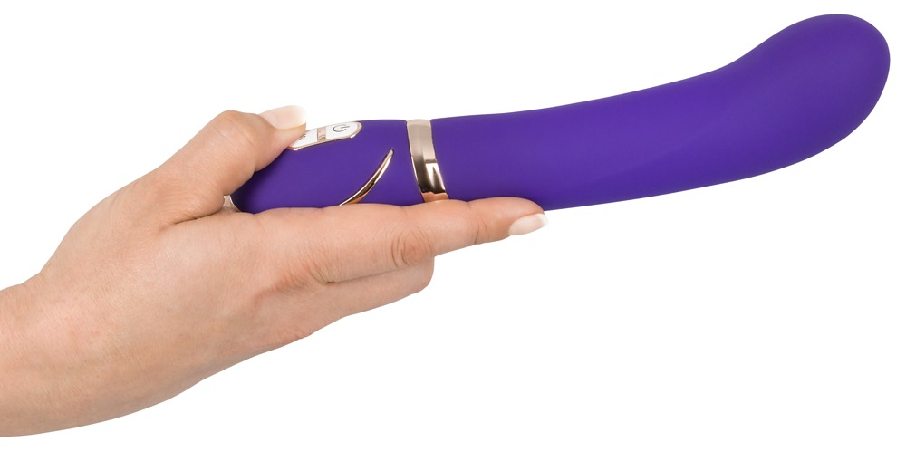 Eine Hand hält ein lila, kurviges Vibratorgerät mit goldenen Akzenten auf weißem Hintergrund.