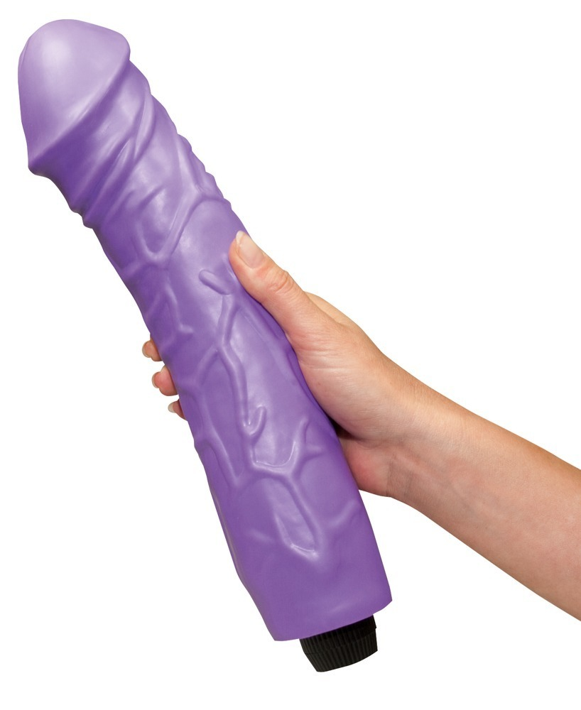 Eine Hand hält einen großen, violetten Dildo mit realistischer Textur und Adern auf weißem Hintergrund.