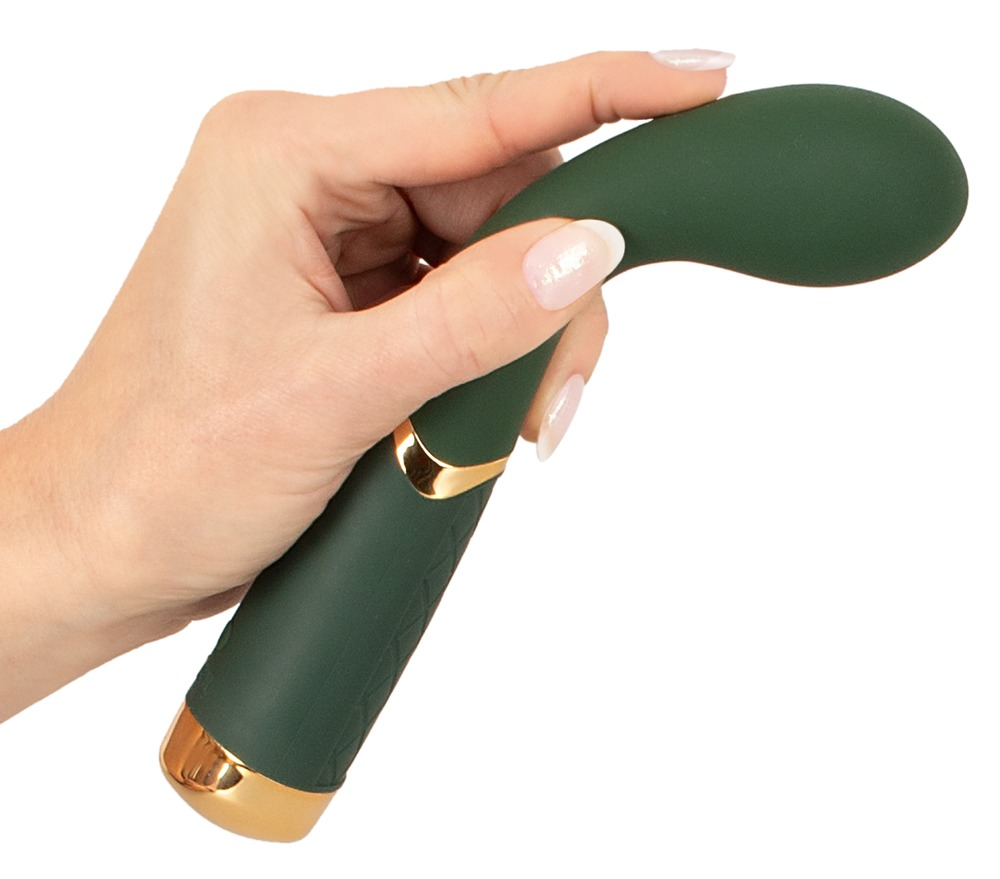 Eine Hand hält einen dunkelgrünen, geschwungenen Vibrator mit goldenen Akzenten vor weißem Hintergrund.