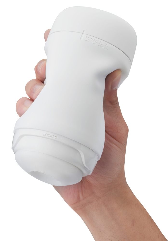 Eine Hand hält einen weißen, biegsamen Tenga-Masturbator gegen einen weißen Hintergrund.