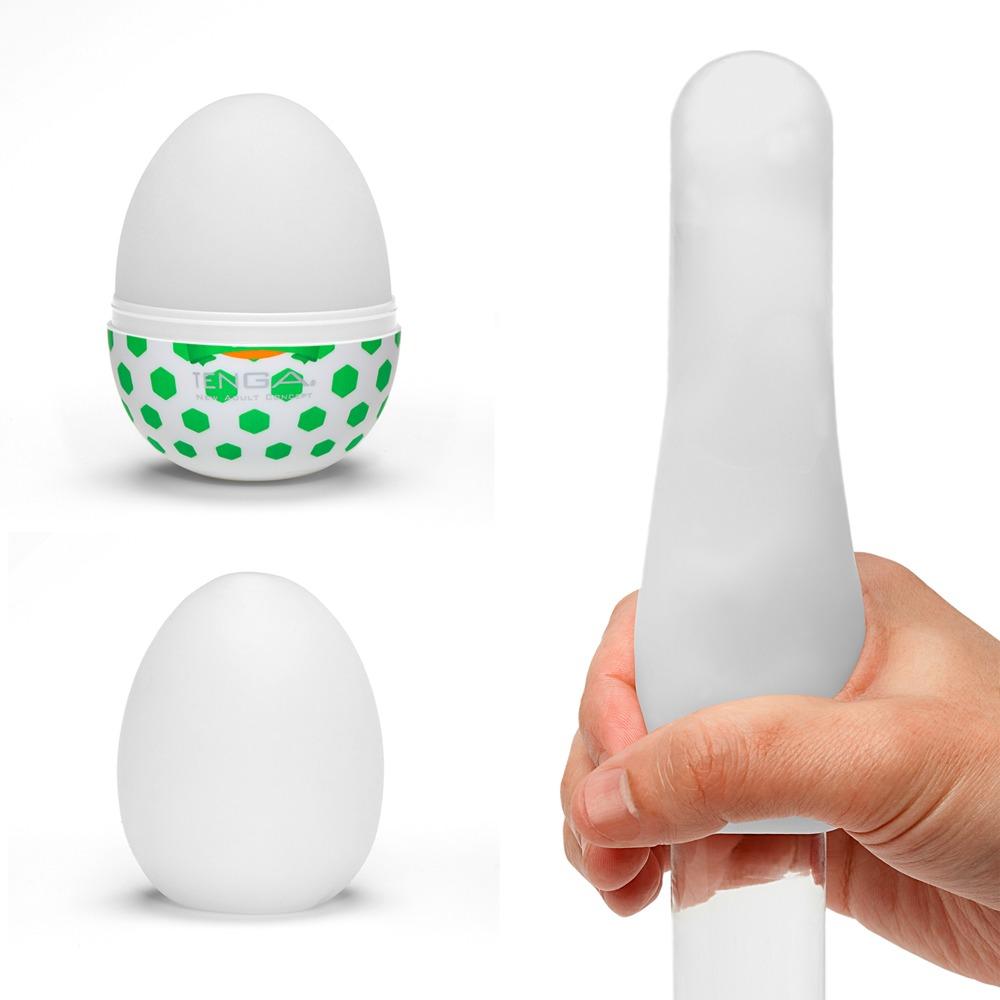 Ein weißes Tenga-Ei mit grünem Muster und eine Hand hält einen länglichen weißen Dildo auf weißem Hintergrund.