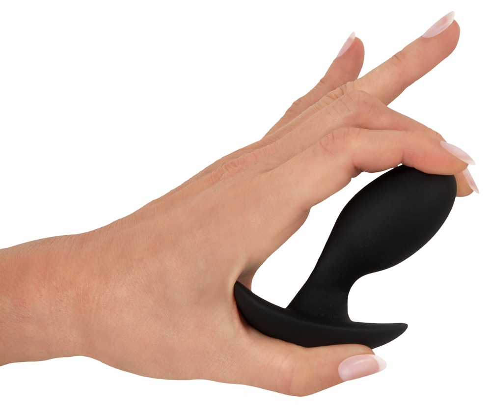 Eine Hand hält ein schwarzes, bogenförmiges Wellness-Accessoire vor weißem Hintergrund.
