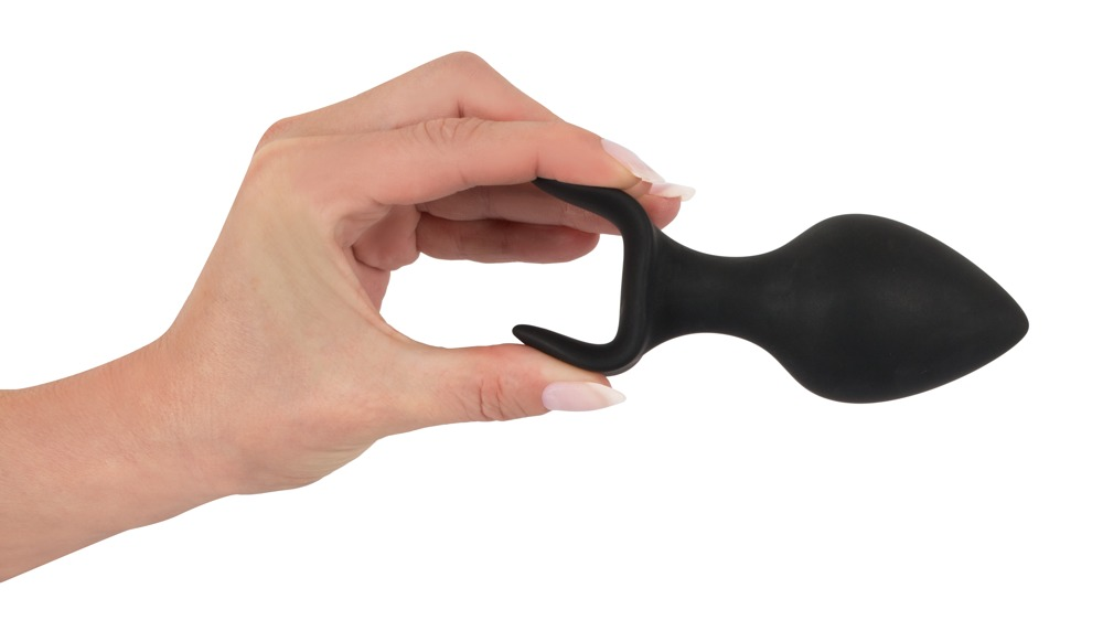 Eine Hand hält einen schwarzen, wellenförmigen Sextoy vor weißem Hintergrund.