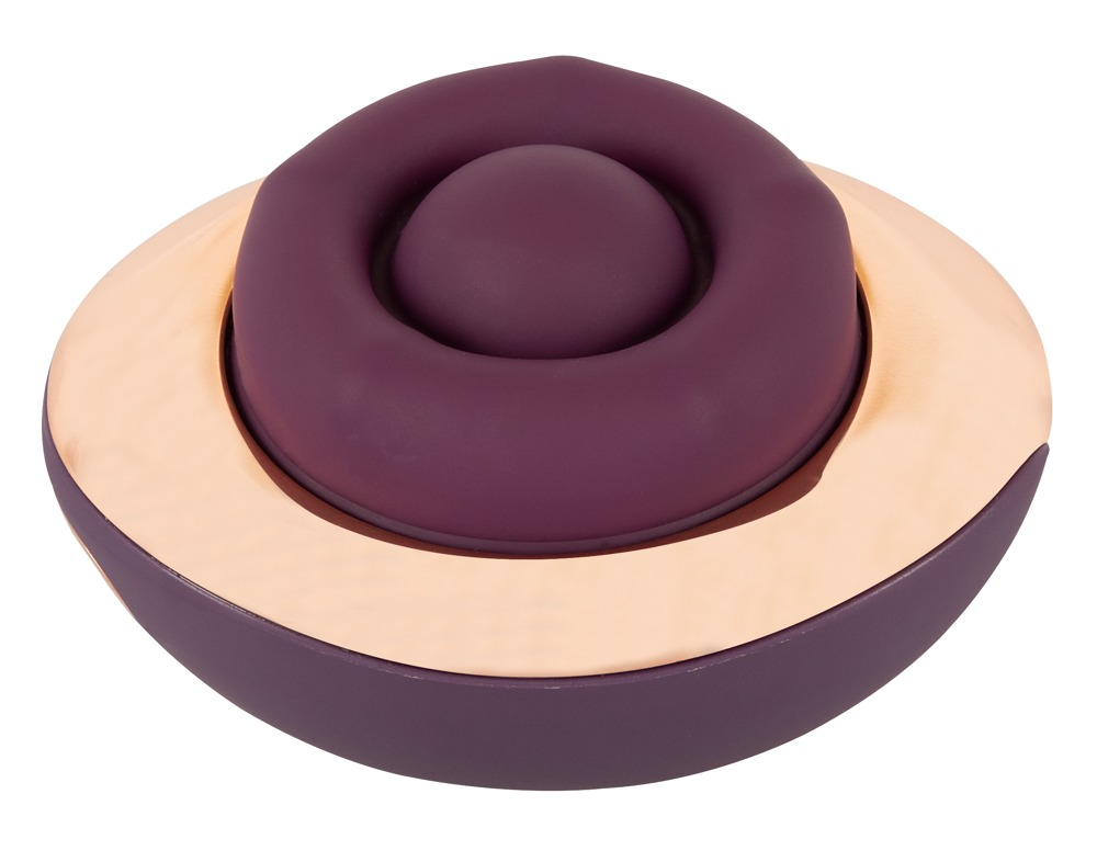 Ein rundes, dunkelviolettes Wellness-Gerät mit einem glänzenden, roségoldenen Akzentring auf weißem Hintergrund.