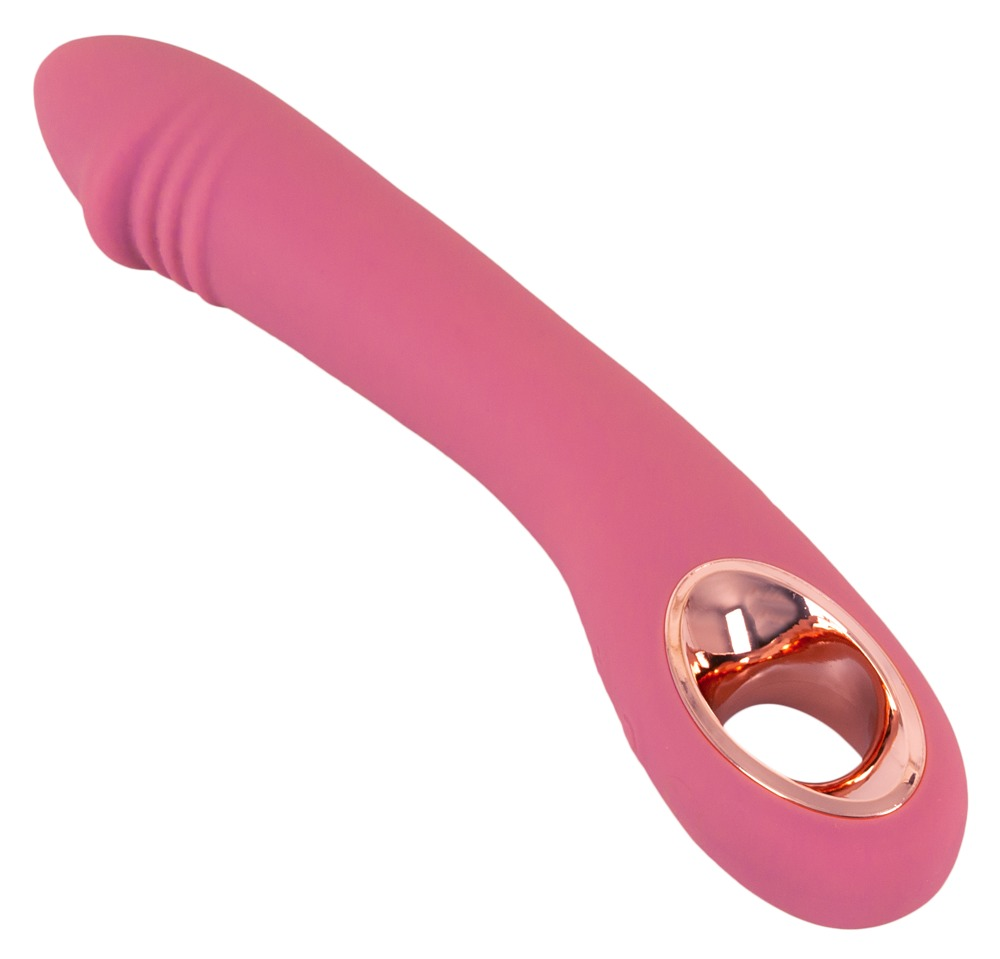 Ein rosa, silikongeformtes Erotikspielzeug mit einem Roségoldring auf weißem Grund.