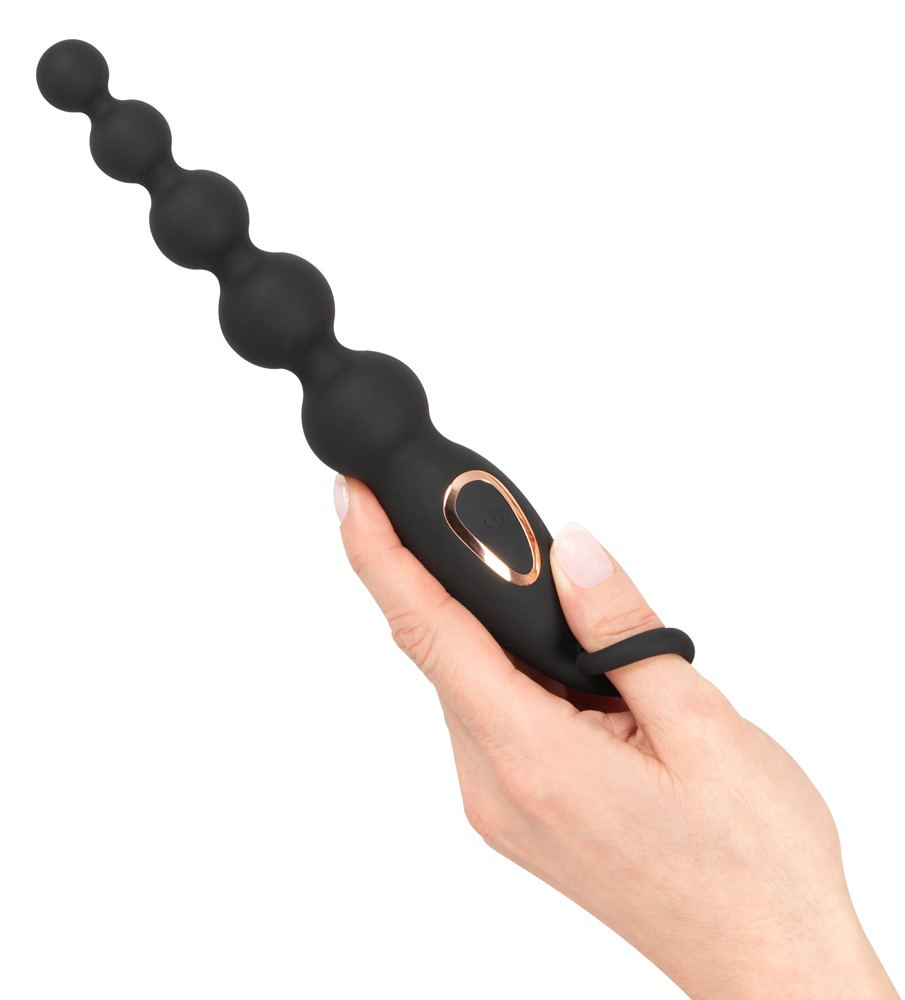 Eine Hand hält einen schwarzen, perlenförmigen Vibrator mit Roségoldakzent.