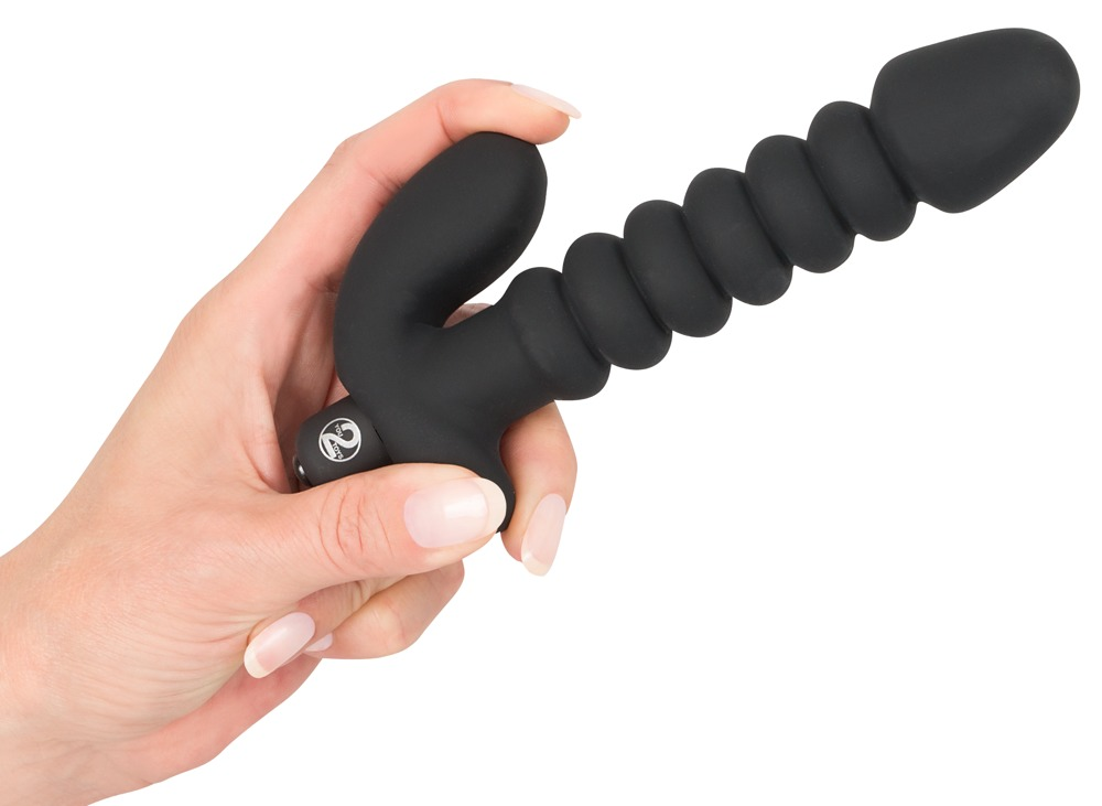 Eine Hand hält ein schwarzes Silikon-Sexspielzeug mit geripptem Schaft und geschwungener Basis vor weißem Hintergrund.