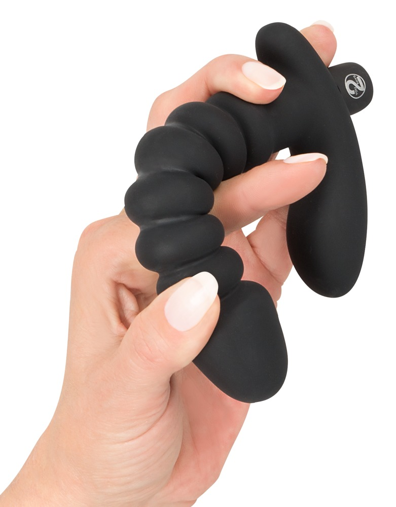 Eine Hand hält ein schwarzes, geripptes Sexspielzeug aus Silikon vor weißem Hintergrund.