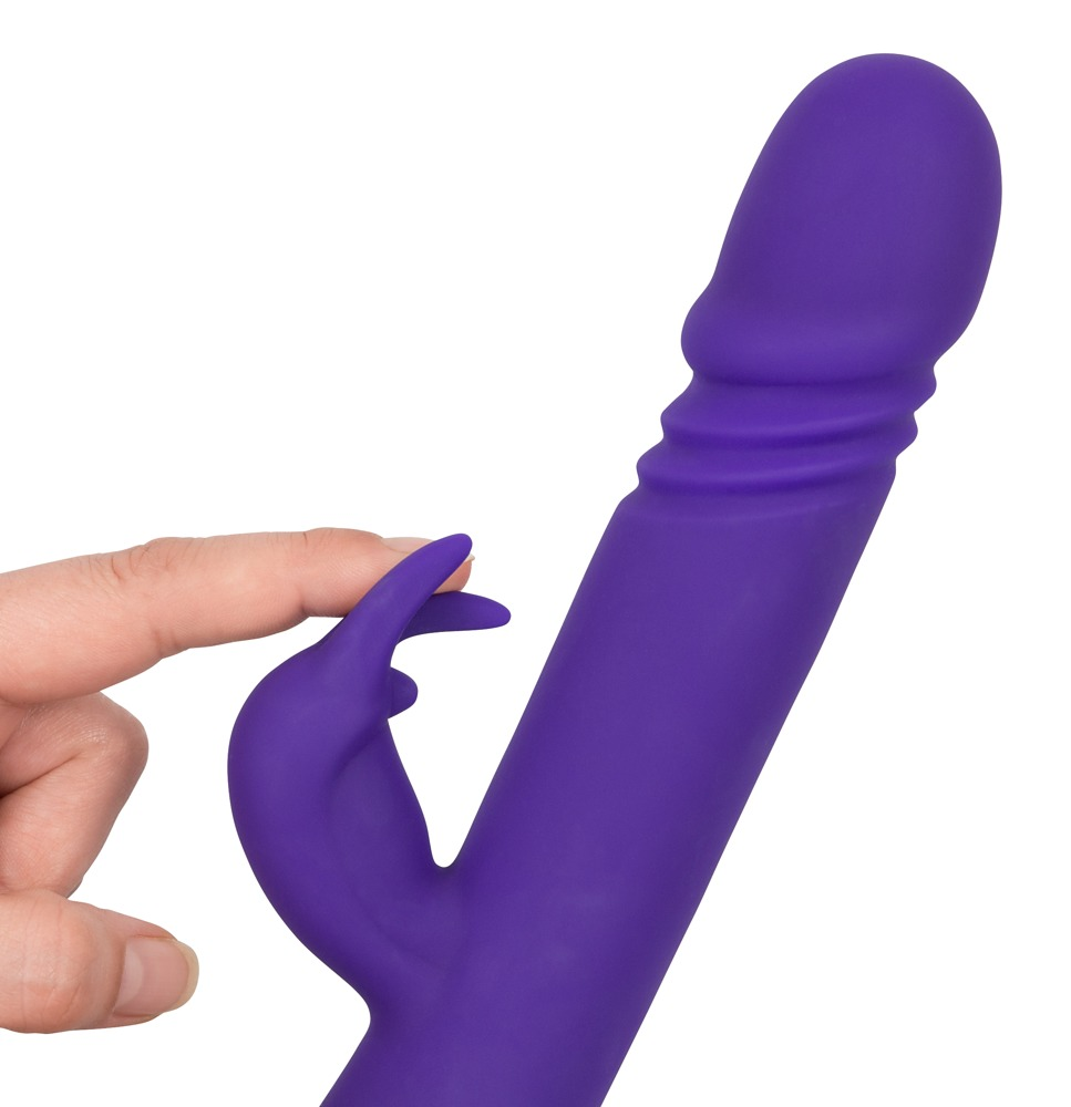 Lila Vibriertes Sexspielzeug mit einem Finger, der den Klitorisaufsatz berührt, vor weißem Hintergrund.
