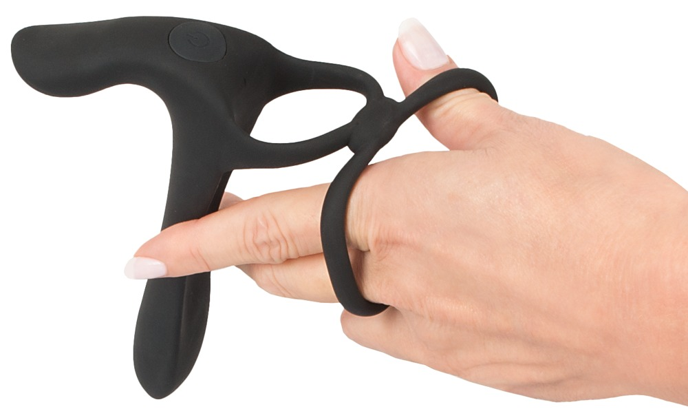 Eine Hand hält ein schwarzes Silikon-Sexspielzeug mit Ringen für die Finger auf weißem Hintergrund.
