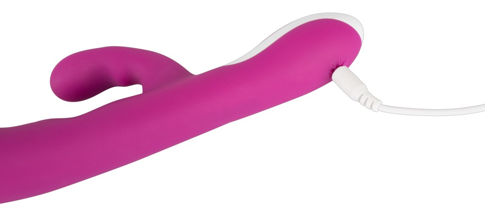 Ein pinkfarbenes, ergonomisches Sexspielzeug mit einem weißen Ladekabel an der Seite vor weißem Hintergrund.