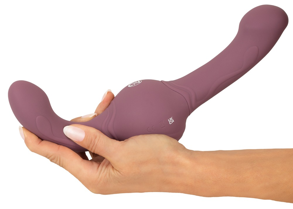 Eine Hand hält einen lila Silikon-Dildo mit ergonomischem Design gegen einen weißen Hintergrund.