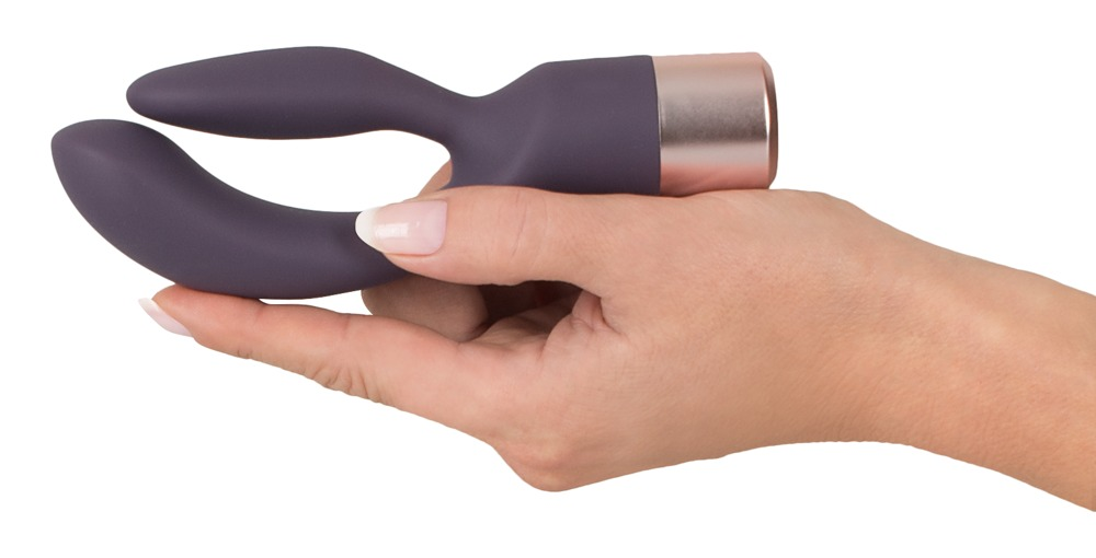 Eine Hand hält einen grauen, Y-förmigen Vibrator mit roségoldenem Rand auf weißem Hintergrund.