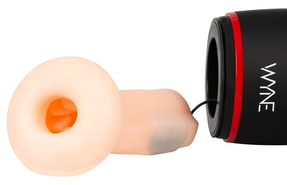 Ein fleischfarbenes Silikonobjekt mit einer inneren Öffnung liegt neben einem schwarzen und roten Wyn-Gerät.