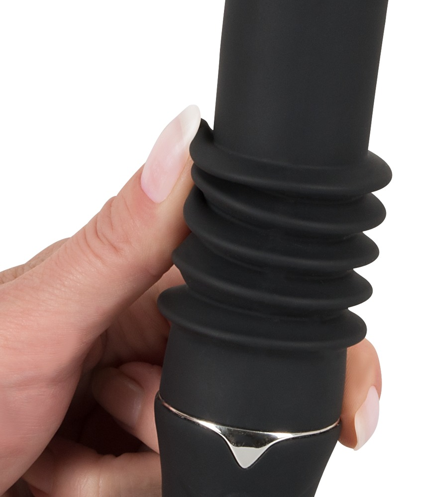 Eine Hand hält ein schwarzes, geripptes Adult-Toy vor weißem Hintergrund.