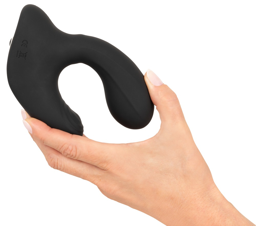 Eine Hand hält ein geschwungenes, schwarzes Wellness-Gerät aus Silikon vor weißem Hintergrund.
