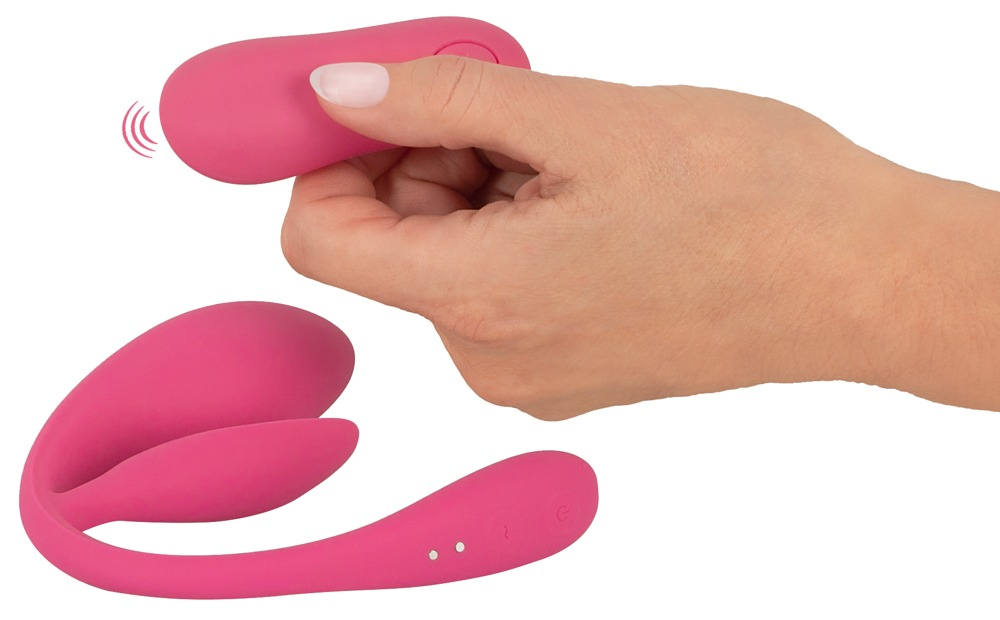 Eine Hand hält eine rosa Fernbedienung neben einem passenden U-förmigen Gerät auf weißem Hintergrund.