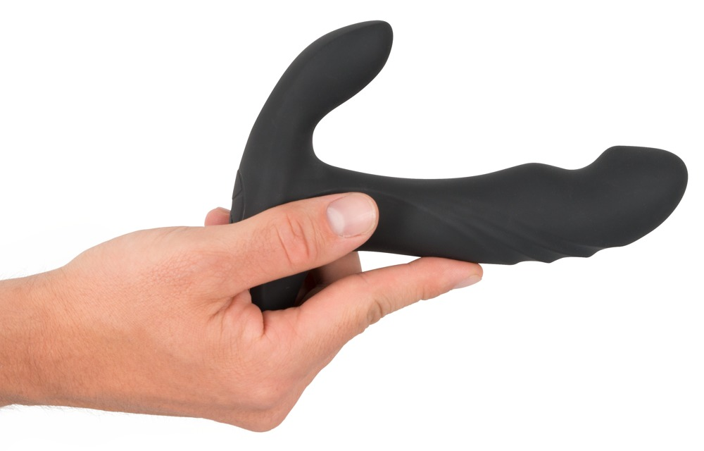 Eine Hand hält ein schwarzes, ergonomisch geformtes Wellnessprodukt auf weißem Hintergrund.